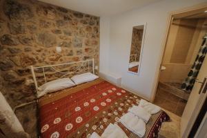 a bedroom with a bed and a stone wall at Eleutheria in Kalamata