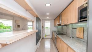 a kitchen with wooden cabinets and a counter top at Apartaments Cambrils Suite Costa Daurada in Cambrils
