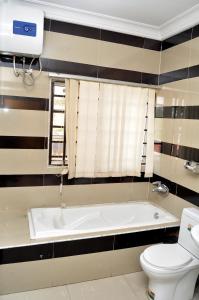 a bathroom with a bath tub and a toilet at Primal Hotel in Ikeja