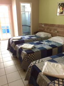 a group of three beds in a room at Hotel Marlin Azul in Vila Velha