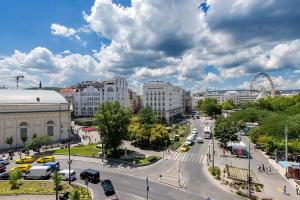 una concurrida calle de la ciudad con coches y una noria en Luxury & Panorama Apartments en Budapest