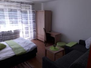 a living room with a bed and a couch and a window at MAXI - Mielenko in Mielenko
