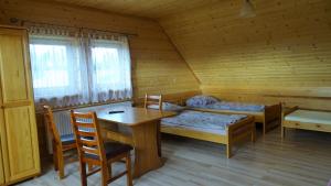 una habitación con 2 camas y una mesa en una cabaña en Chata Istebna, en Istebna
