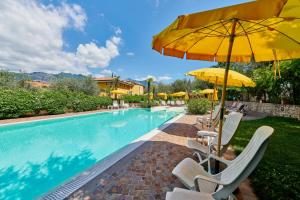 einen Pool mit Stühlen und Sonnenschirmen neben einem Pool in der Unterkunft Hotel Catullo in Malcesine