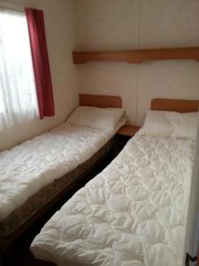 Кровать или кровати в номере Šventojoje nameliai Žibų 99
