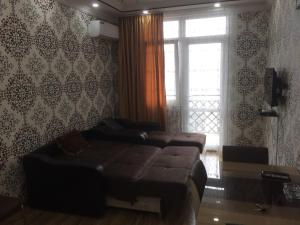 a bedroom with a bed and a window and a couch at Gorgasali street Apartment in Batumi