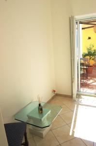 a room with a glass table on a tiled floor at La Terrazza sul Mare in Capri