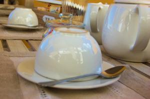 a glass tea pot on a plate with a spoon at La Terrazza sul Mare in Capri