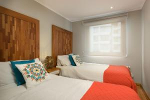 1 dormitorio con 2 camas y ventana en Casa Bellavista Hotel, en Santiago