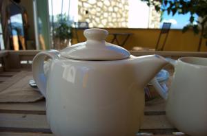 a white tea pot and a cup on a table at La Terrazza sul Mare in Capri