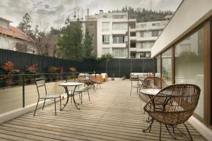a patio with chairs and tables on a balcony at Casa Bellavista Hotel in Santiago
