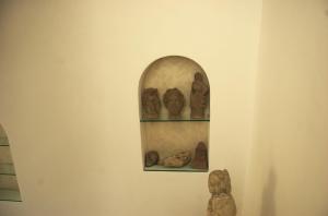 a wall with two shelves with sculptures on it at La Terrazza sul Mare in Capri