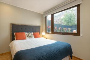 a bed sitting in front of a window next to a window at Casa Bellavista Hotel in Santiago