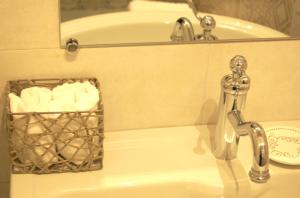 a bathroom sink with a faucet and a basket of towels at La Terrazza sul Mare in Capri