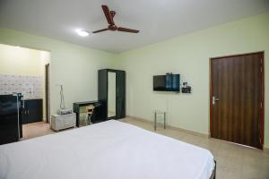 1 dormitorio con 1 cama y ventilador de techo en Sunshine Park Homes, en Colva