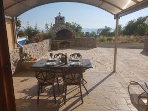 a table in a patio with a fireplace at Guest House Suzana in Omišalj