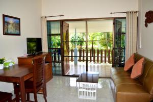 a living room with a couch and a table at Kate House Bangsaphan in Bang Saphan