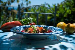a blue plate of food on a table with apples at Hotel Palladio in Giardini Naxos