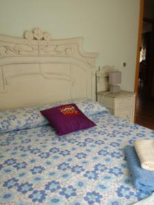 a bed with a purple pillow on top of it at Apartamento Ade in El Campello