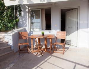 una mesa de madera y sillas en un patio en Solymar, en Loutsa