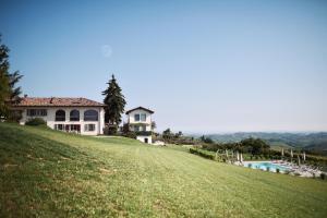 a house on top of a hill with a swimming pool at La Cascina Della Musica in Costigliole dʼAsti