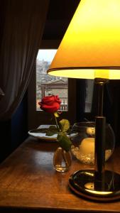 un tavolo con una lampada e una rosa rossa sopra di Hotel Relais Filonardi a Veroli