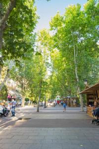 マドリードにあるPiso Moderno Centro Madridの通りの人々と木々が生い茂る公園
