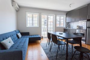 a living room with a blue couch and a table at Oporto City View - Santo Ildefonso in Porto