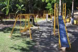 a playground with yellow equipment in a park at Pousada carvalho in Conselheiro Lafaiete