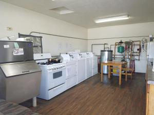 a kitchen with white appliances and a wooden floor at Tarragon Motel in Marinette