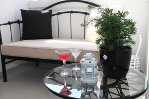 a glass table with two glasses on top of a couch at Apartman Tara in Split