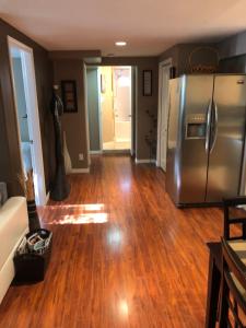 a living room with a stainless steel refrigerator at Cozy and modern 3 bedroom in central location! in Victoria