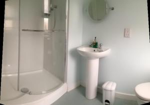 a white bathroom with a sink and a shower at Heather Glen Guest House in Elgin