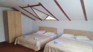 due letti in una stanza con finestra di Vila Azuga ad Azuga