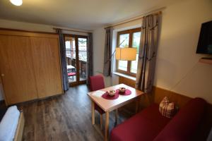 a living room with a red couch and a table at Ferienhof Sonnschein in Sölden