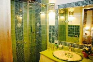 W wyłożonej zielonymi kafelkami łazience znajduje się umywalka i prysznic. w obiekcie Romeo e Giulietta Scilla w mieście Scilla