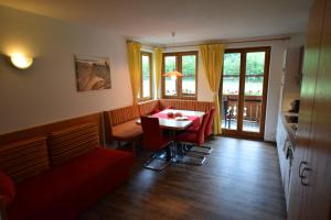 a dining room with a table and red chairs at Ferienhof Sonnschein in Sölden