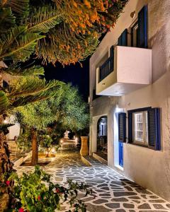 une passerelle en pierre avec des plantes et un bâtiment dans l'établissement Acrogiali Beachfront Hotel Mykonos, à Platis Gialos