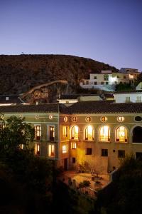 un gran edificio con sus luces encendidas por la noche en Hotel Casa de los Arcos, en Vélez Blanco