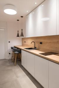 スプリトにあるBCAdria apartmentsの白いキャビネットとシンクのあるキッチン