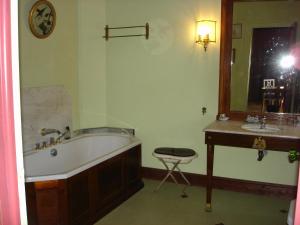 y baño con bañera, lavabo y espejo. en Manoir de Keroman, en Languidic