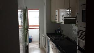 a small kitchen with a sink and a window at Apartamento O pombal in Cambados