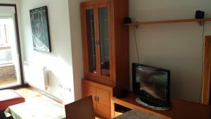 a living room with a tv and a wooden cabinet at Apartamento O pombal in Cambados
