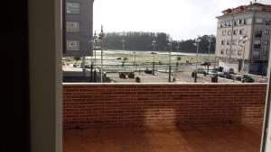 a window with a view of a parking lot at Apartamento O pombal in Cambados