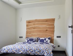 a bedroom with a bed with a wooden headboard at Blue Door Apartment Ground Floor in Augustów