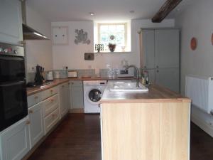 uma cozinha com um lavatório e uma máquina de lavar louça em Manor House Annex - Sleeps up to 6 People em Shepton Mallet