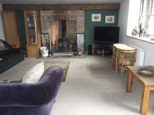 sala de estar con sofá y chimenea en Manor House Annex - Sleeps up to 6 People en Shepton Mallet