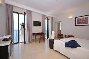 a hotel room with a bed and a table and chairs at I Bastioni San Domenico - Boutique Hotel in Gallipoli
