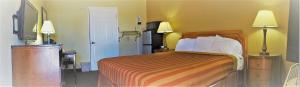 a hotel room with a bed and a kitchen at Executive Inn Mojave in Mojave