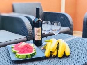 una mesa con una bandeja de fruta y una botella de vino en Apartament El Castillo De Bonalba, en Mutxamel